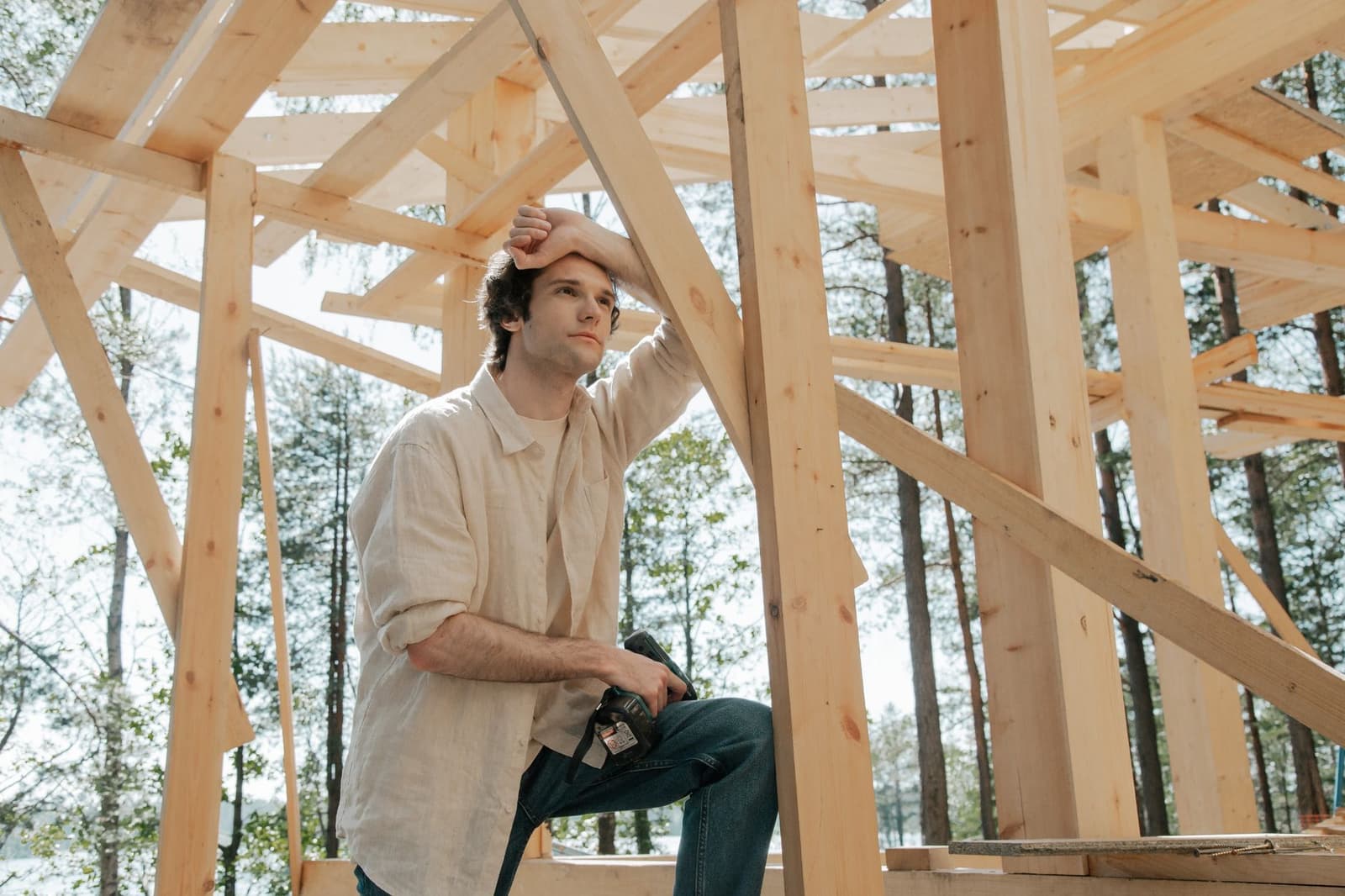 Man with drill inside a timber roof frame